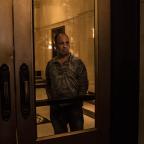 A man watches the protests from inside the Mayo Hotel.