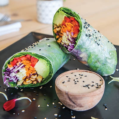 Pure’s Green Dragon Sushi Roll features red bell pepper, carrot, English cucumber, avocado, chili-spiced cashews and more—served with a side of almond ancho chili sauce. 