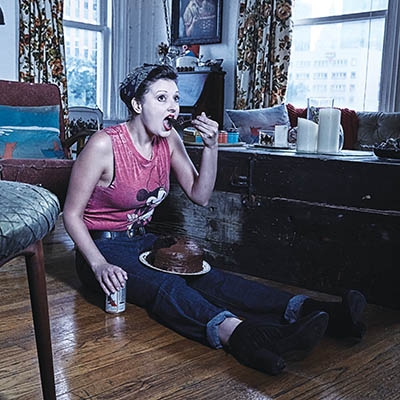 Food writer Angela Evans dressed as a Greaser, eating chocolate cake on the floor like Two-Bit in 