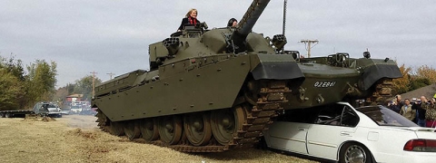 Gov. Mary Fallin rides in a tank as it crushes a Toyota Camry at the grand opening of Wilshire Gun in Oklahoma City