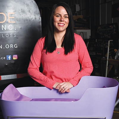 Jaxon Kade Foundation co-founder Brittany Martin stands with a Caring Cradle