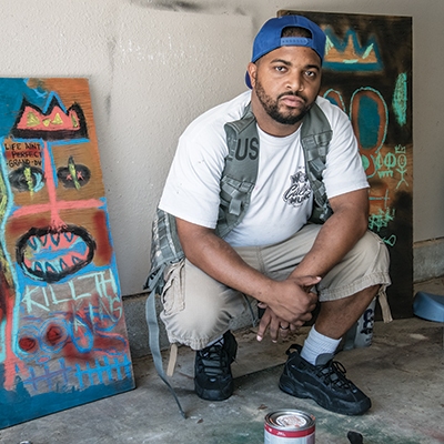 Rap artist Antonio Andrews, aka Dialtone, with his paintings